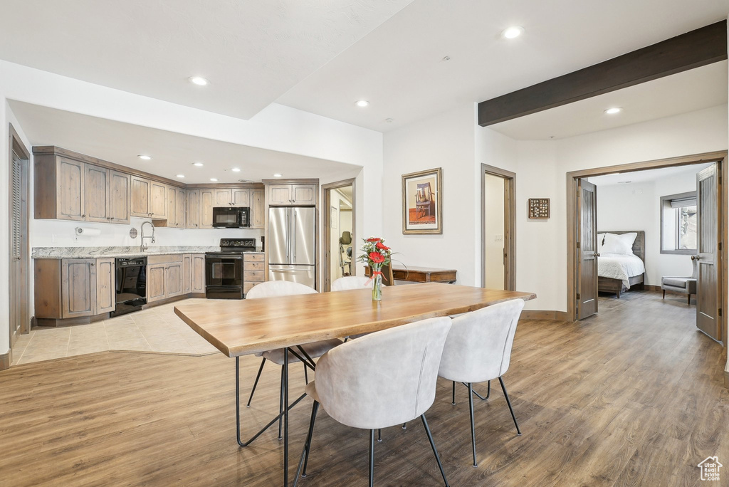 Dining room with light wood finished floors, recessed lighting, and baseboards