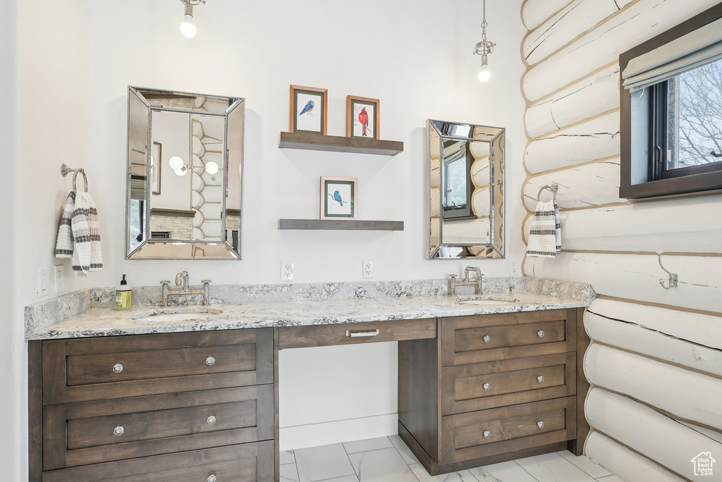 Bathroom with double vanity and marble finish floors