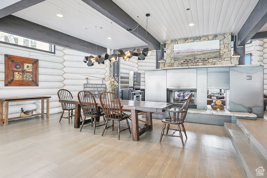 Dining space featuring wood finished floors, log walls, wooden ceiling with exposed beams, and recessed lighting