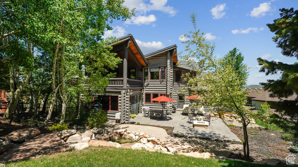Rear view of house featuring a patio and a balcony