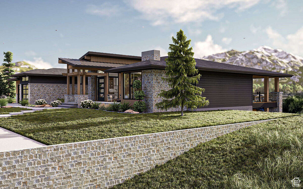 View of front facade featuring a front yard, a chimney, and a standing seam roof