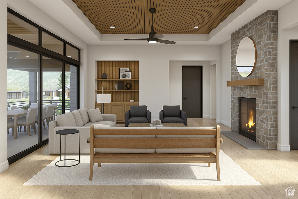 Living area featuring a tray ceiling, hardwood / wood-style flooring, a stone fireplace, a ceiling fan, and wooden ceiling