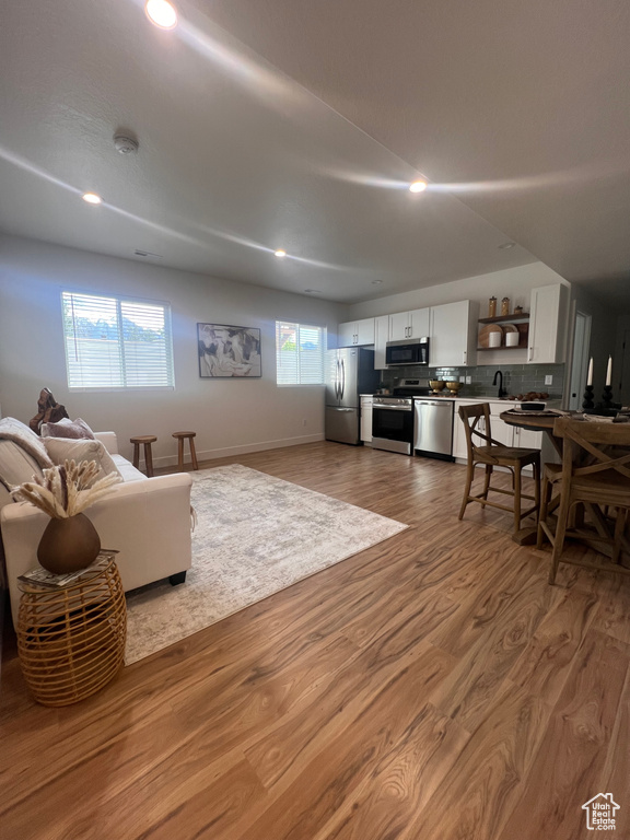 Living room featuring recessed lighting, wood finished floors, and baseboards