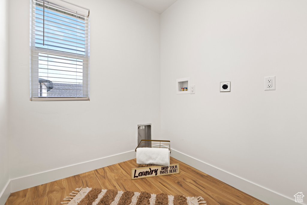 Laundry area with hookup for an electric dryer, washer hookup, baseboards, and wood finished floors