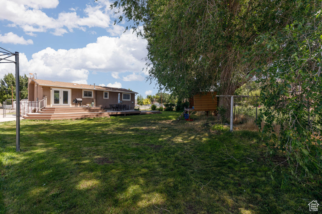 View of yard featuring french doors and a wooden deck
