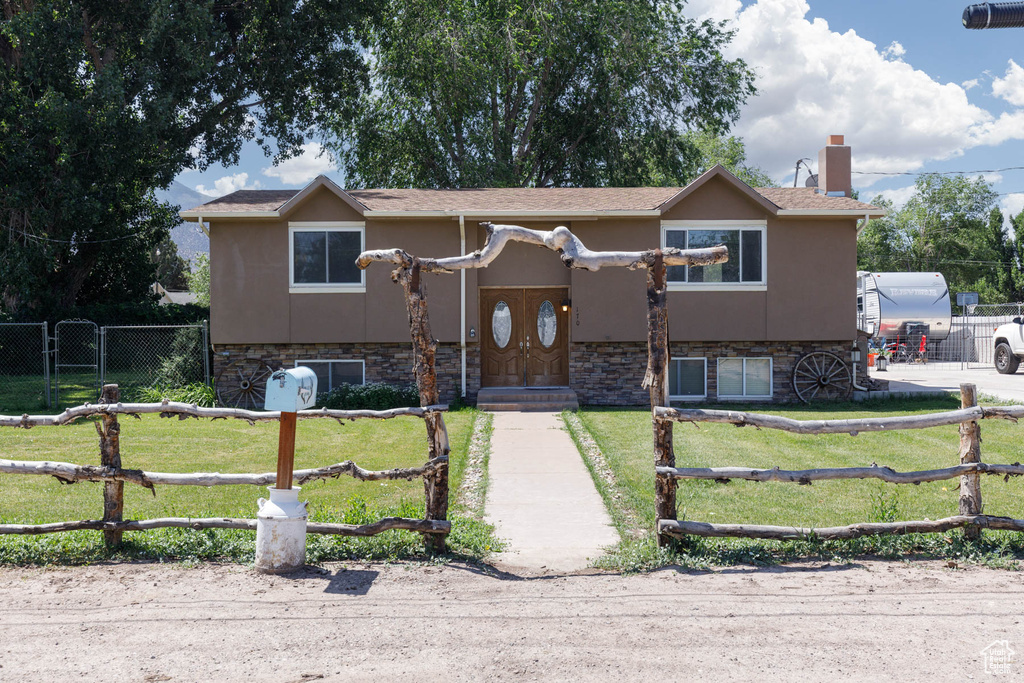 View of front of property featuring stone siding, stucco siding, and a chimney