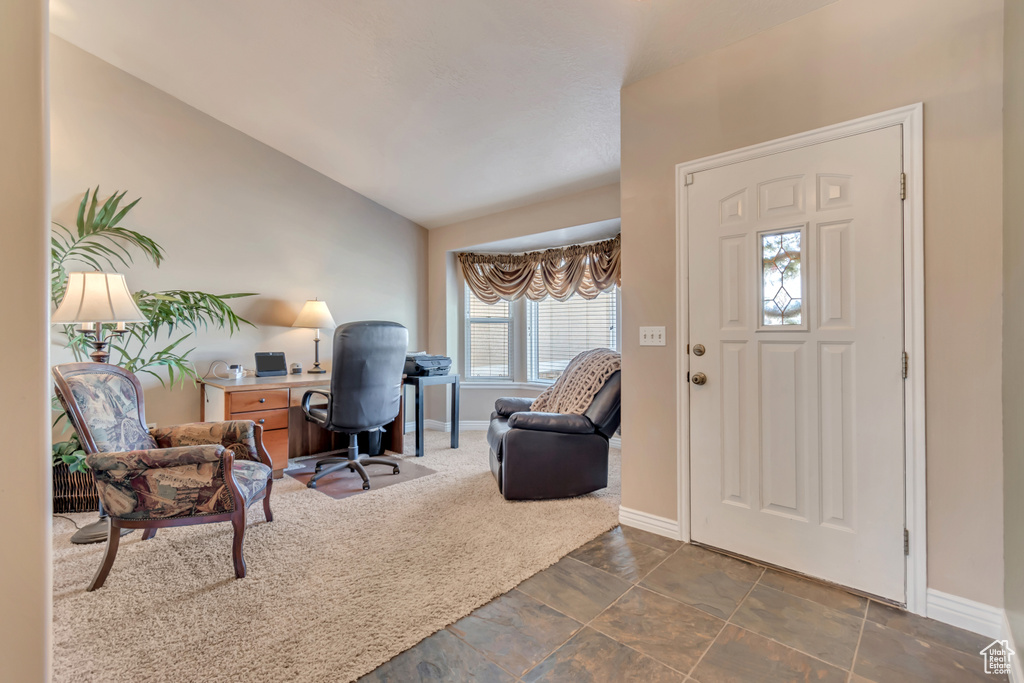 Entryway featuring baseboards, lofted ceiling, and carpet floors