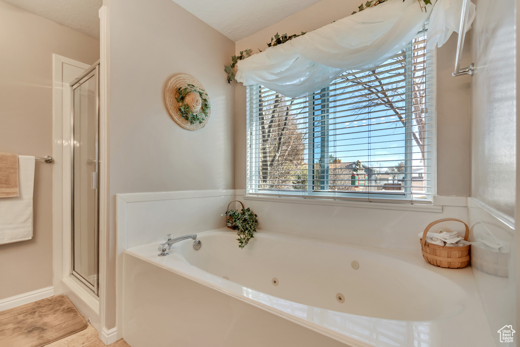 Full bath featuring a stall shower and a jetted tub