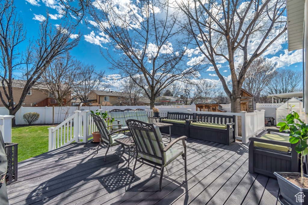 Wooden terrace with a fenced backyard and outdoor lounge area
