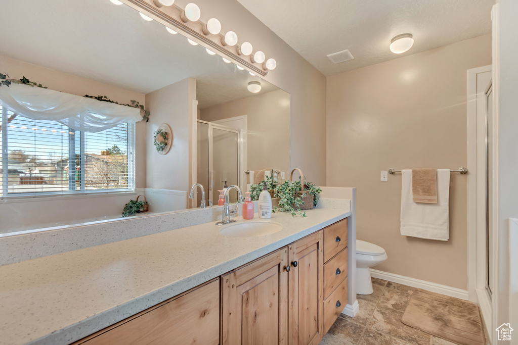 Full bathroom with vanity, toilet, baseboards, a shower stall, and visible vents