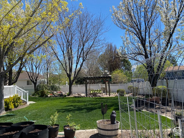 View of yard featuring a pergola and a fenced backyard