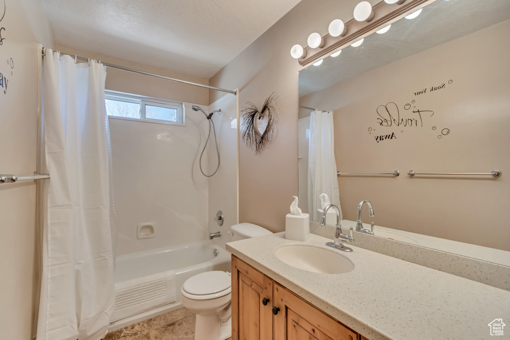 Bathroom featuring shower / tub combo with curtain, toilet, tile patterned floors, and vanity