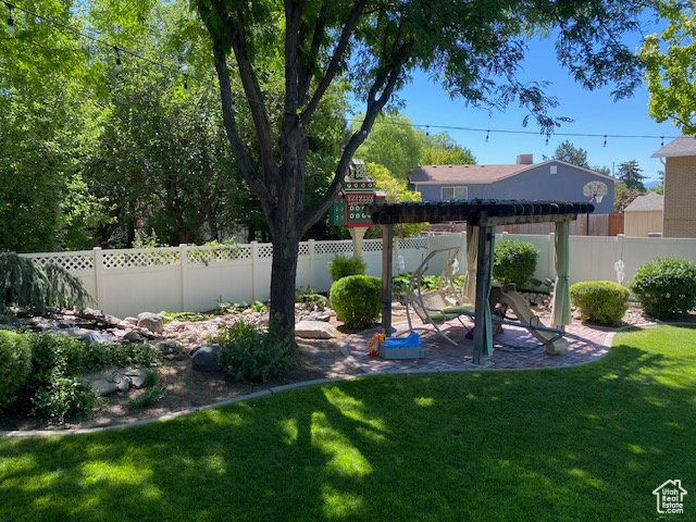 View of yard featuring a pergola, a fenced backyard, and a patio
