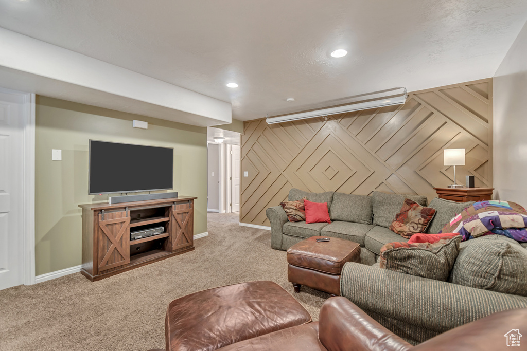 Carpeted living area featuring baseboards, recessed lighting, and an accent wall