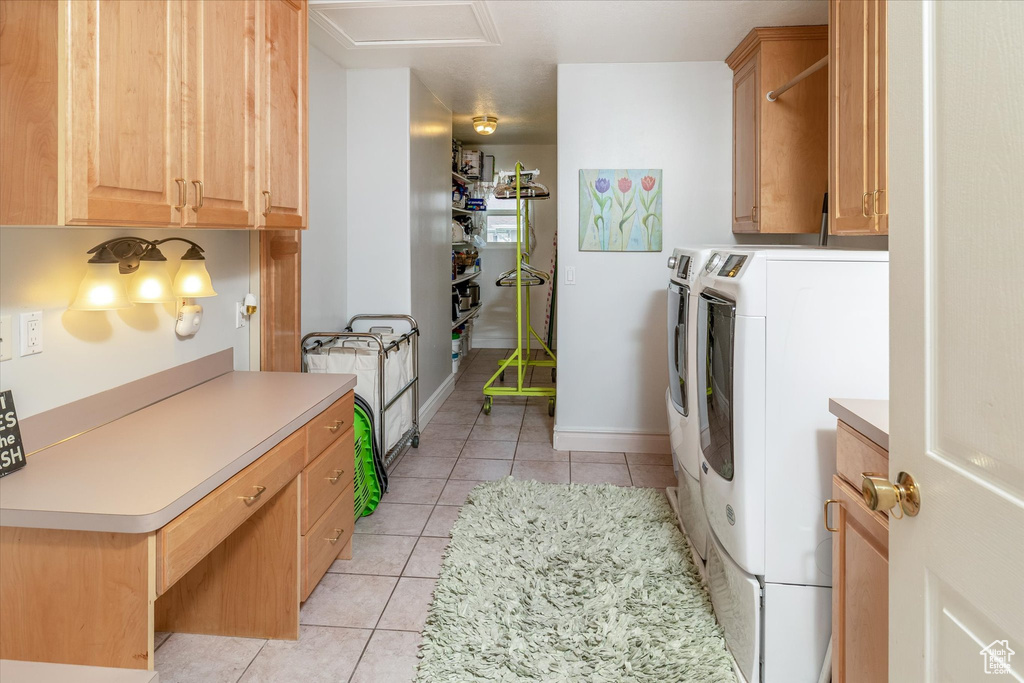 Laundry room featuring separate washer and dryer, cabinet space, and light tile patterned floors