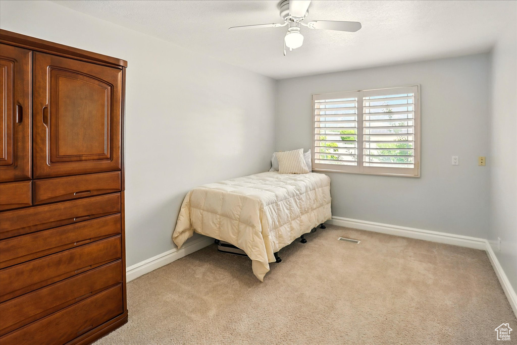 Bedroom with light colored carpet and ceiling fan