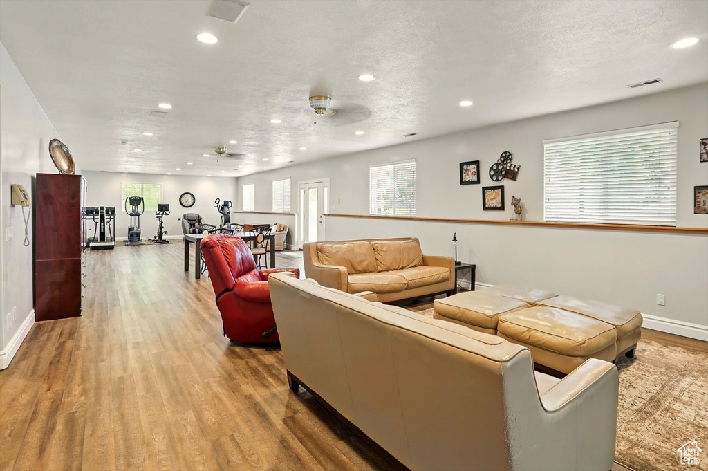 Living area with recessed lighting, wood finished floors, and a ceiling fan