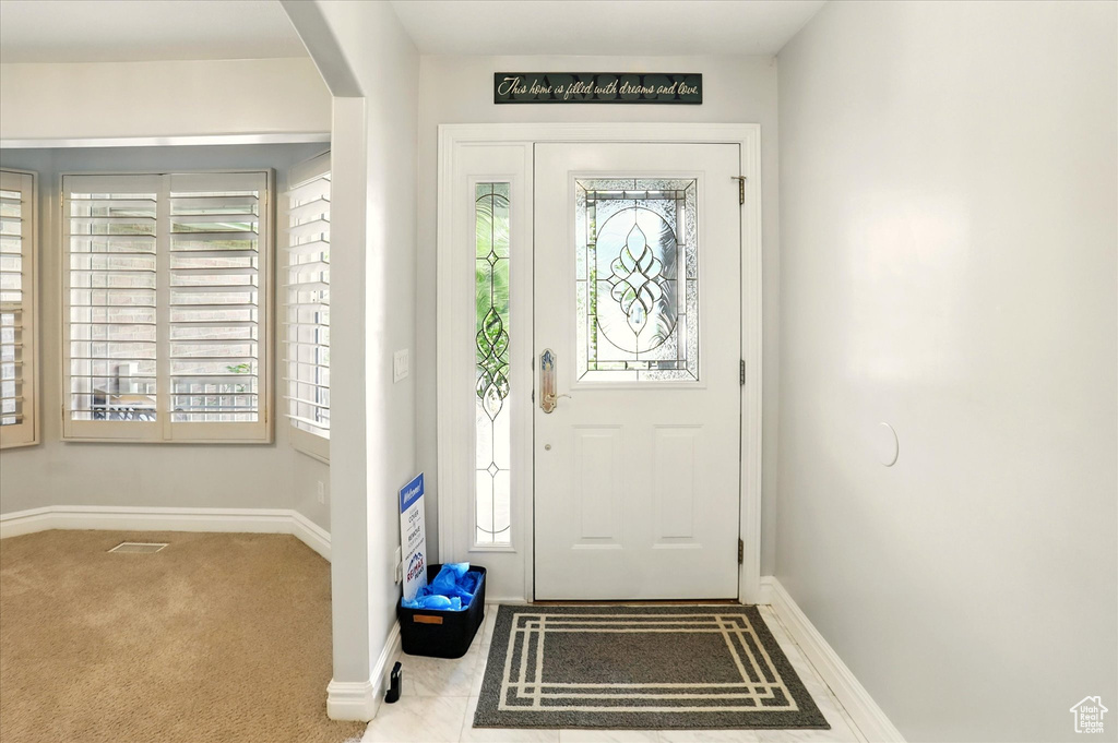 Foyer entrance featuring arched walkways and carpet floors