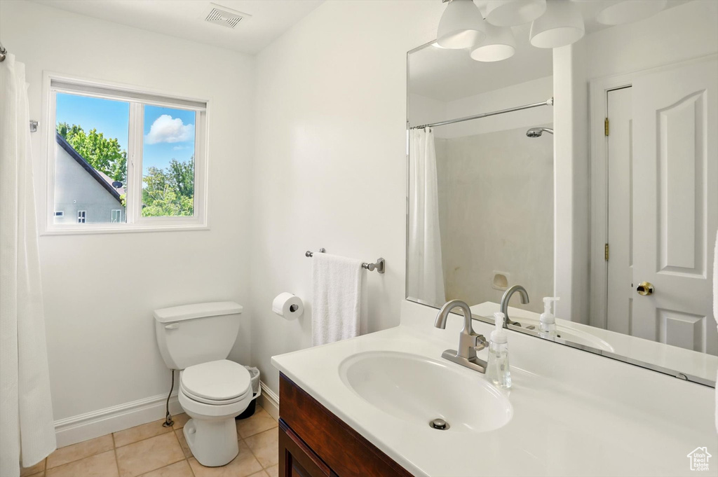 Full bath with vanity, tile patterned floors, and curtained shower