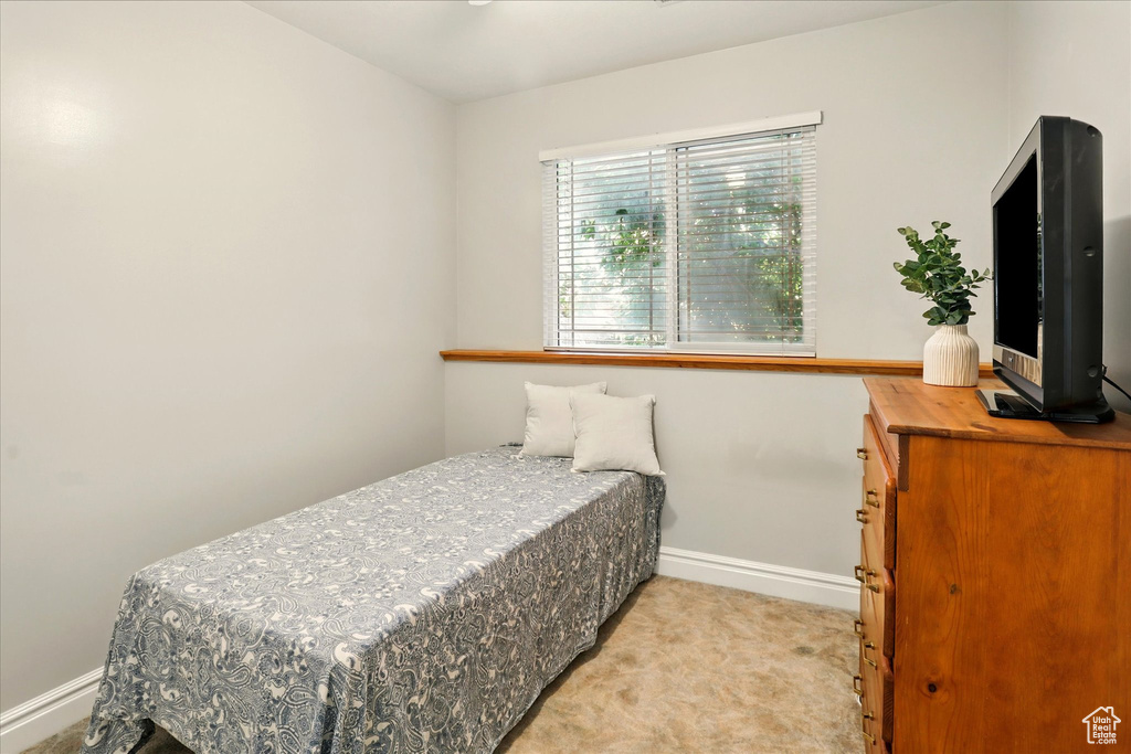 Bedroom featuring baseboards and light colored carpet