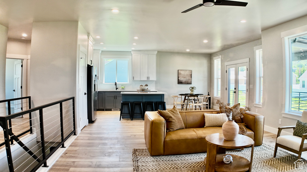 Living room with recessed lighting, light wood-style floors, a ceiling fan, and french doors