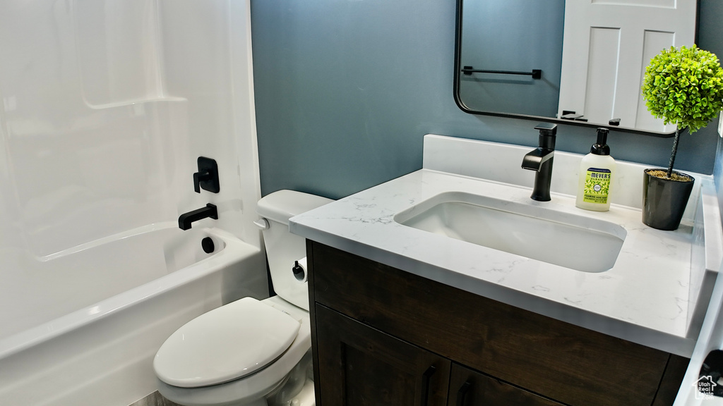 Bathroom with toilet, vanity, and shower / bathtub combination