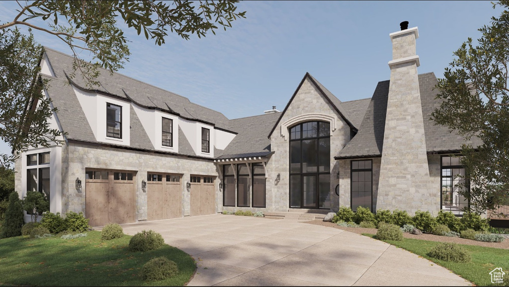 View of front of house featuring stone siding, driveway, and an attached garage