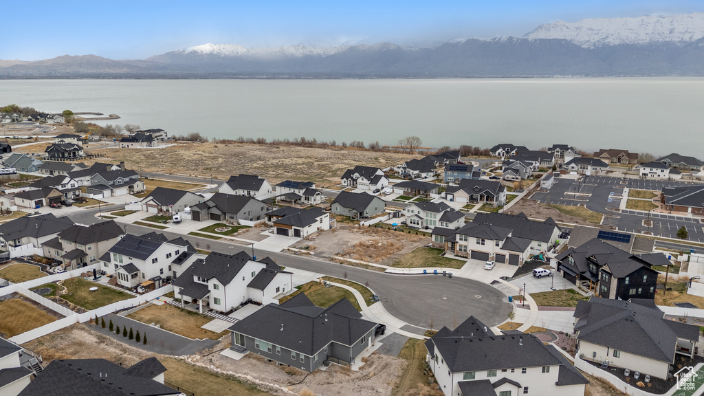 Aerial view of property's location featuring a water and mountain view and nearby suburban area