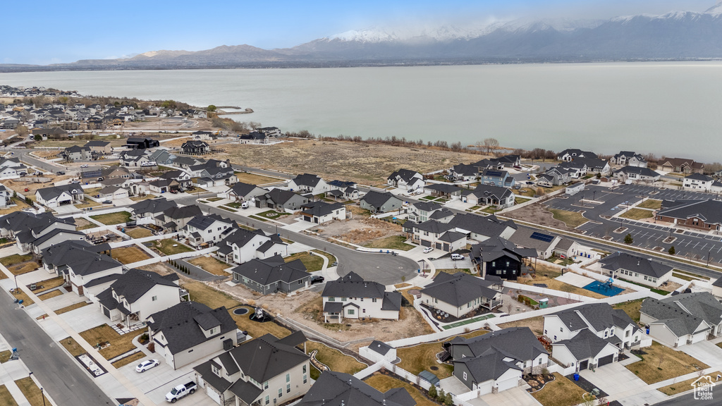 Aerial view of property and surrounding area featuring a water and mountain view and nearby suburban area