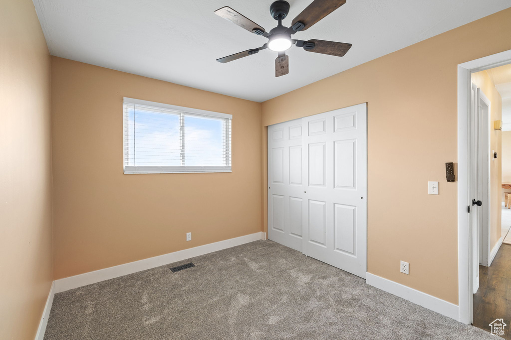 Unfurnished bedroom featuring a closet, carpet floors, visible vents, and baseboards