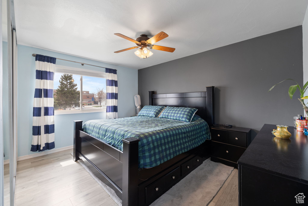 Bedroom with baseboards, light wood-style floors, and a ceiling fan