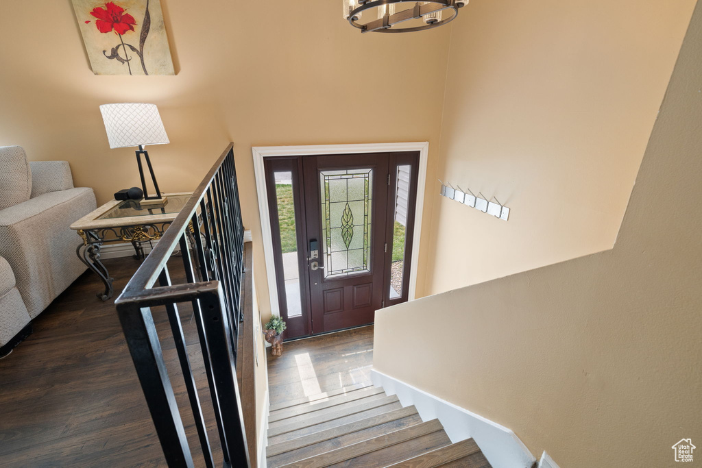 Foyer featuring stairs, wood finished floors, and a chandelier