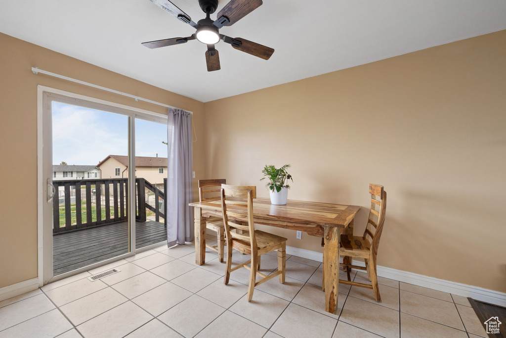Dining area with light tile patterned flooring, baseboards, visible vents, and ceiling fan