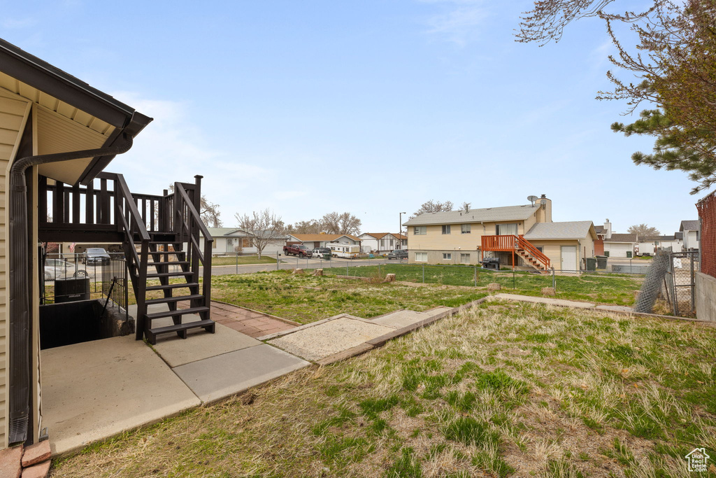View of yard with a residential view, stairway, fence, and a wooden deck
