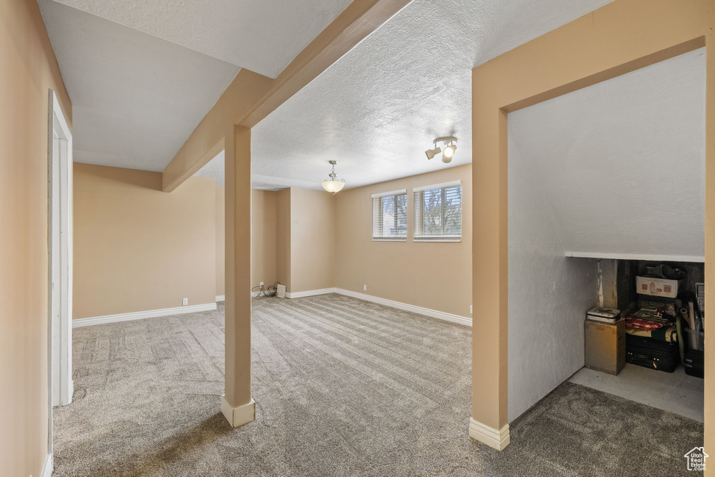 Below grade area with baseboards, carpet, and a textured ceiling