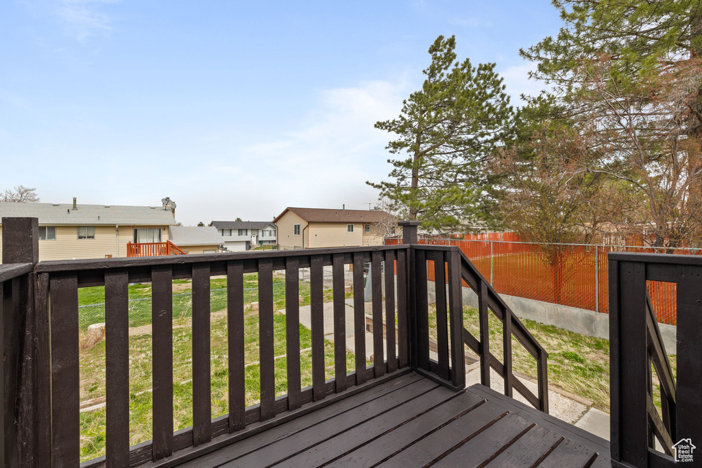 Wooden deck featuring fence and a lawn
