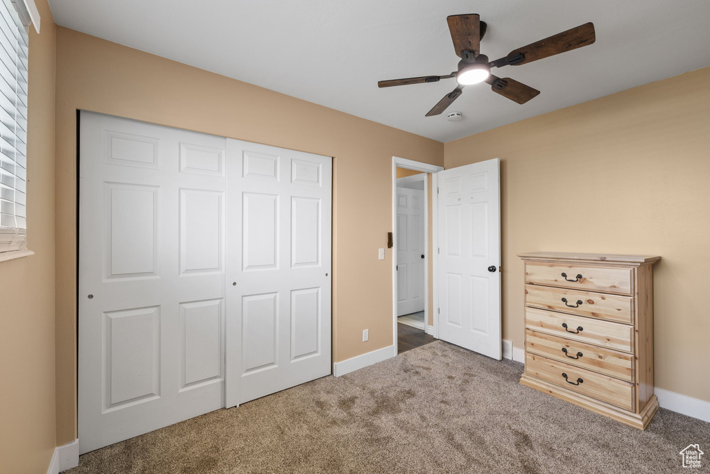 Unfurnished bedroom featuring baseboards, a closet, carpet, and a ceiling fan