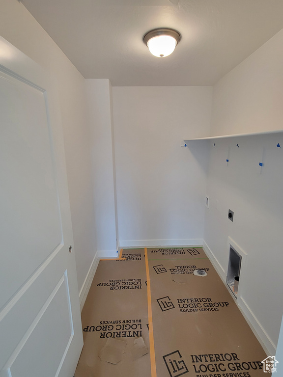 Clothes washing area with hookup for an electric dryer, baseboards, and laundry area