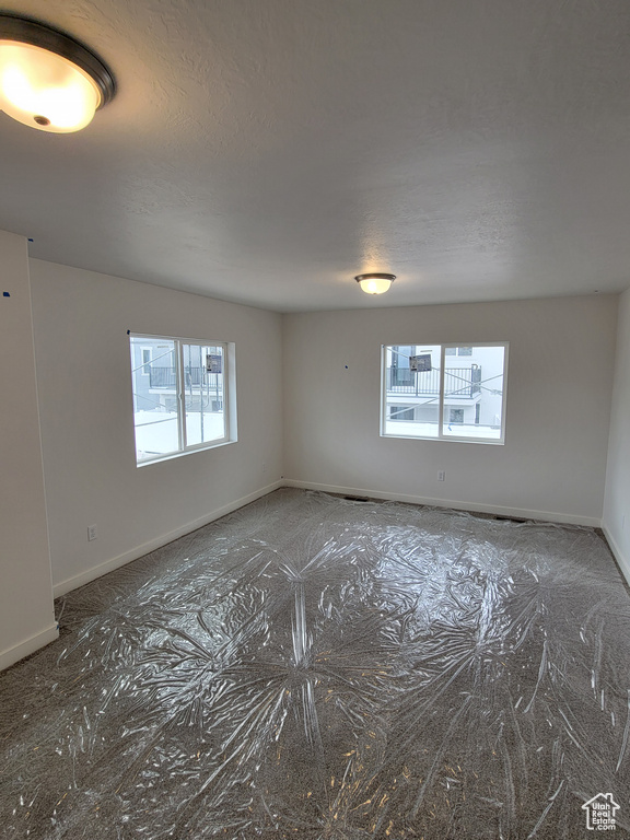Spare room with baseboards and a textured ceiling