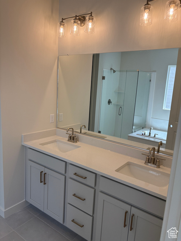 Full bathroom featuring a stall shower, tile patterned floors, a bath, and double vanity