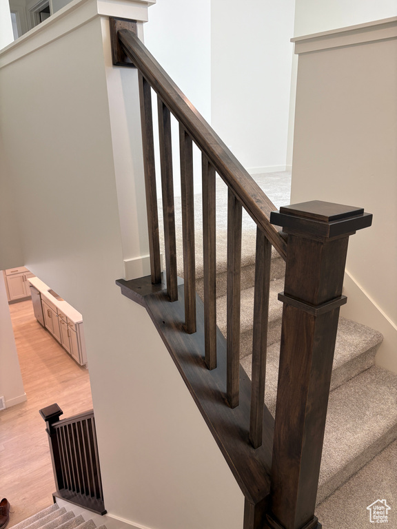 Stairs with wood finished floors and baseboards