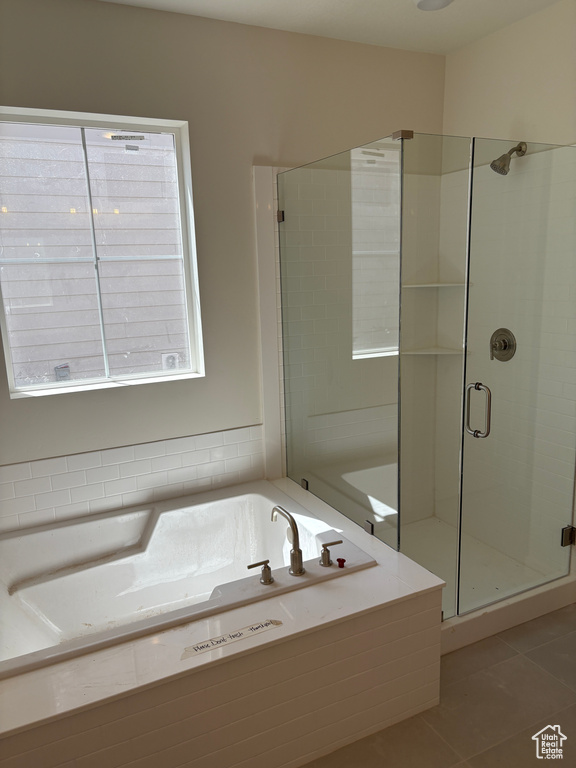 Full bathroom with tile patterned floors, a stall shower, and a bath