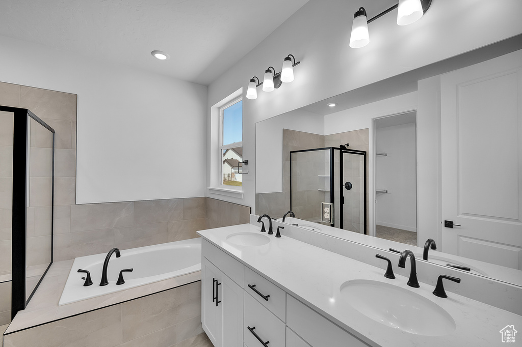 Full bath with a shower stall, a bath, double vanity, and recessed lighting