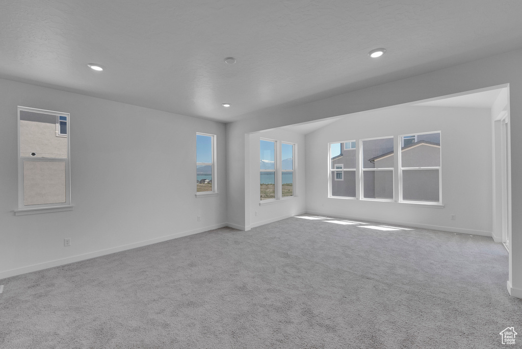 Carpeted empty room with baseboards and recessed lighting