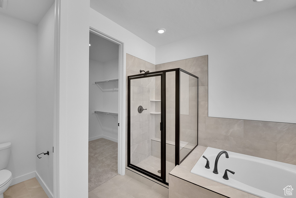 Bathroom featuring toilet, a garden tub, a stall shower, a walk in closet, and recessed lighting