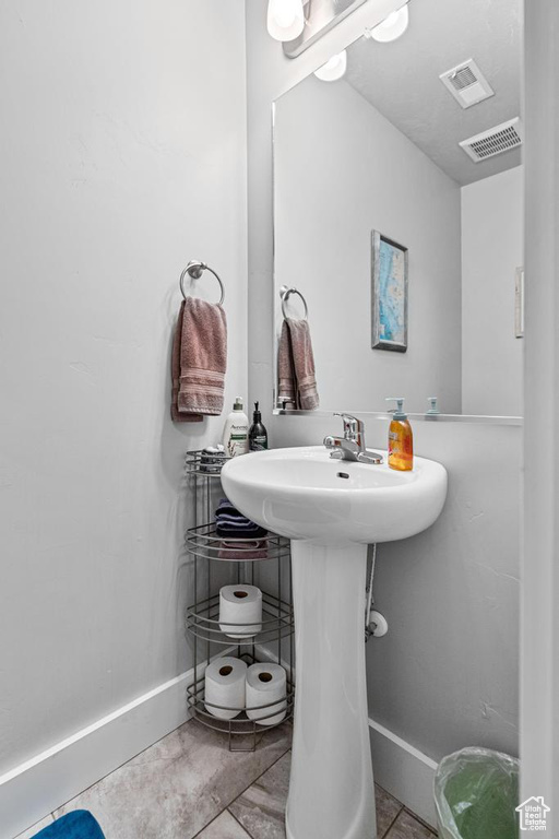 Half bathroom featuring baseboards and a sink