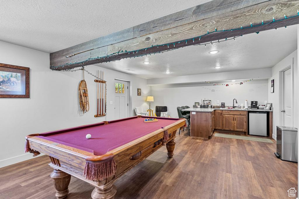 Playroom featuring wet bar, a textured ceiling, wood finished floors, billiards table, and baseboards