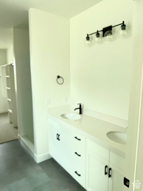 Bathroom featuring double vanity, a shower, and a sink