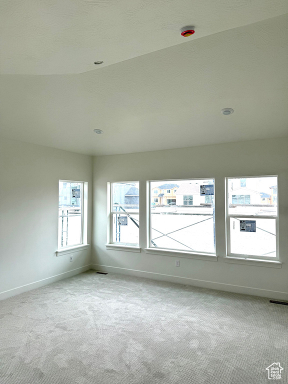 Spare room featuring carpet floors, baseboards, and visible vents