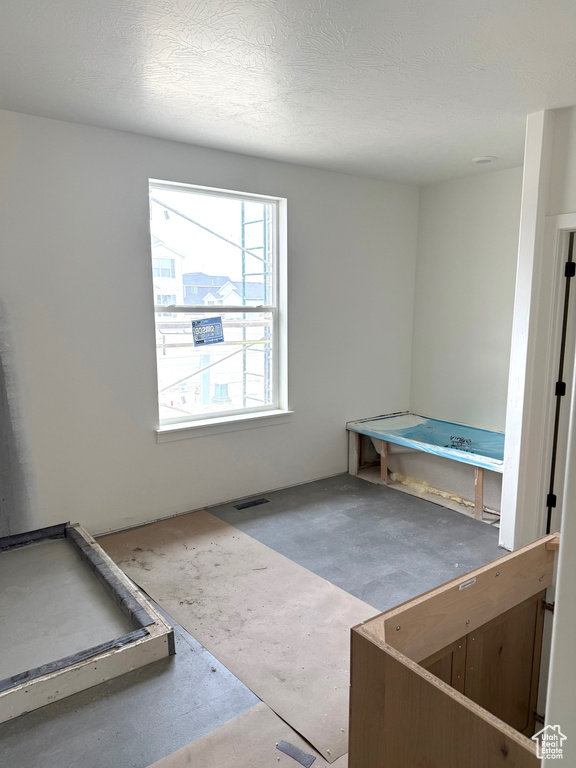 Interior space with a textured ceiling and visible vents